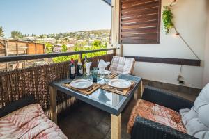 a table with wine bottles and glasses on a balcony at Ti Kaz Oreo - Cosy Plage & confort - Wiskeys in Saint-Gilles les Bains