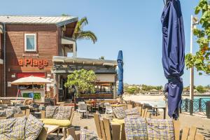 a group of chairs and umbrellas in front of a restaurant at Ti Kaz Oreo - Cosy Plage & confort - Wiskeys in Saint-Gilles les Bains