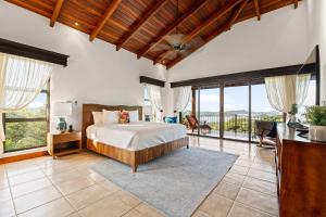 a bedroom with a bed in a room with windows at Spectacular Ocean Views Infinity Pool in Potrero
