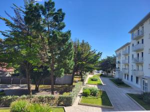 ein Mehrfamilienhaus mit Bäumen und einem Bürgersteig in der Unterkunft Appartement à Saint-Brevin-les-Pins - 4 pers, 2 terrasses et vue mer - FR-1-364-173 in Saint-Brevin-les-Pins