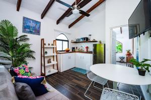 a living room with a white table and a kitchen at Couples Tropical Getaway with Pool, Playa Potrero in Potrero