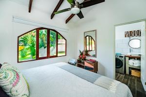 a bedroom with a bed with a ceiling fan at Couples Tropical Getaway with Pool, Playa Potrero in Potrero +7 photos