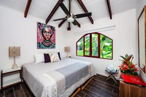 a bedroom with a bed and a ceiling fan at Couples Tropical Getaway with Pool, Playa Potrero in Potrero