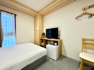 a bedroom with a bed and a tv and a chair at Y&Y NAMBA HOTEL Osaka in Osaka
