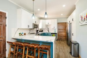 a kitchen with white cabinets and a blue island at Wake Up to Ocean Views, Pool, Walk to Sandy Beach in Tamarindo