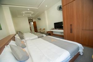 a hotel room with two beds and a desk at Garden Hotel II in Ha Giang