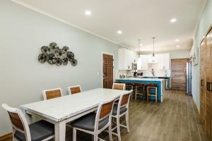 a kitchen and dining room with a white table and chairs at Wake Up to Ocean Views, Pool, Walk to Sandy Beach in Tamarindo