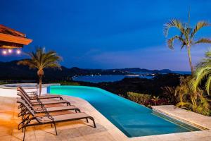 a pool with chairs and a view of the ocean at Infinity Pool Villa with Ocean & Mountain Views in Potrero