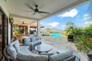 a patio with couches and a table and a pool at Infinity Pool Villa with Ocean & Mountain Views in Potrero +19 photos