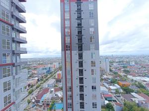 a view of a city from between two tall buildings at Comfort and Strategic 2BR Apartment at Vida View Makassar By Travelio in Pampang