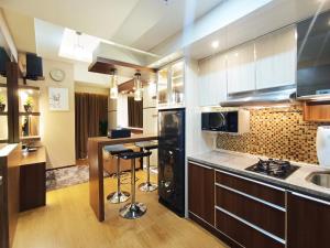 a kitchen with a counter and a bar in it at Comfort and Strategic 2BR Apartment at Vida View Makassar By Travelio in Pampang