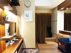 a room with a living room with a couch and a room with at Comfort and Strategic 2BR Apartment at Vida View Makassar By Travelio in Pampang