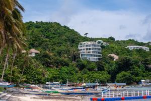 a bunch of boats on the beach with a building at Bolabog Beach Resort in Boracay
