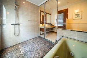 a bathroom with a tub and a glass shower at KOKO HOTEL Osaka Shinsaibashi in Osaka +48 photos