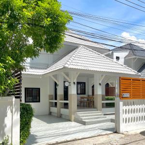 a white house with a white fence at Cozy House, Wonnapha Beach, Bangsaen in Ban Bang Saen (1)