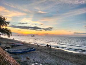 a group of people on a beach at sunset at Villa Avila Muelle Moñitos Isla fuerte in Moñitos +16 photos