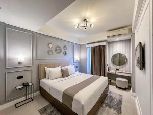 una camera da letto con un letto grande e una scrivania di Hotel FortunaGrande Malioboro Yogyakarta a Yogyakarta Altre 37 foto