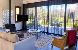 a living room with a couch and a large window at Amaroo Valley Springs in Barrengarry