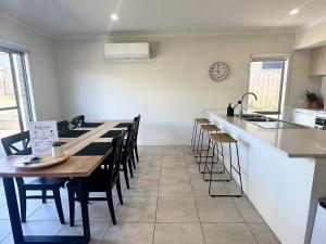 Una cocina y un comedor con mesa y sillas. en Coastal Oasis - 10 mins to Torquay, 10 mins to Geelong !, en Mount Duneed