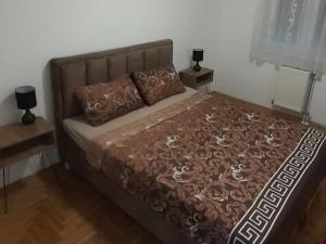 un letto in una camera da letto con due lampade su due tavoli di Sirmijum Hause II a Sremska Mitrovica