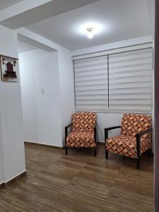 two chairs sitting next to each other in a room at Dormitorio matrimonial 01 in Lima