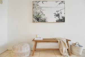 a wooden table in a room with a picture on the wall at Chic 2 bdrm Poolside Apartment in Noosa Heads