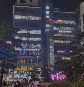 a tall building with lit up windows at night at Gwangalli Tahee House in Busan
