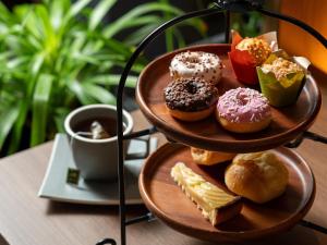 a tray of donuts on a table with a cup of coffee at Glamday Style Okinawa Yomitan Hotel & Resort in Yomitan