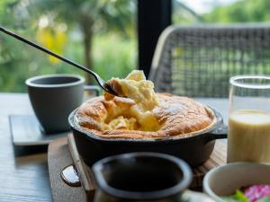 a bowl of food on a table with a spoon at Glamday Style Okinawa Yomitan Hotel & Resort in Yomitan