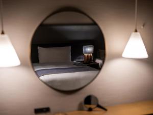 a bedroom with a bed and a mirror on the wall at Glamday Style Okinawa Yomitan Hotel & Resort in Yomitan