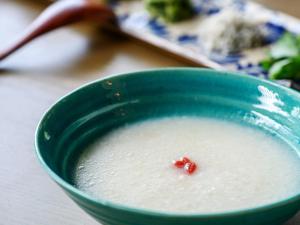 a green bowl of soup with a red object in it at Glamday Style Okinawa Yomitan Hotel & Resort in Yomitan