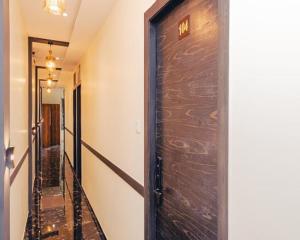 a wooden door in a hallway with a hallway leading into a room at Hotel Golden Sands Inn Aslpha in Mumbai