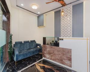 a living room with a blue couch in a room at Hotel Golden Sands Inn Aslpha in Mumbai