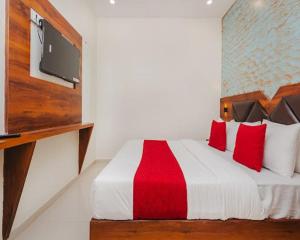 a bedroom with a bed with a red and white blanket at Hotel Golden Sands Inn Aslpha in Mumbai