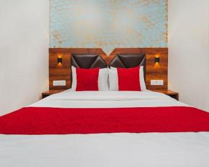a bedroom with a large bed with red pillows at Hotel Golden Sands Inn Aslpha in Mumbai