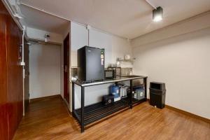 a room with a table with a tv in it at Ed Hostel Rachamakka in Chiang Mai