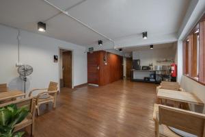 an empty room with wooden tables and chairs and a kitchen at Ed Hostel Rachamakka in Chiang Mai