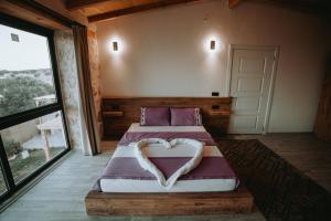 a bedroom with a bed with a heart shaped pillow at villa sunrise in Demre