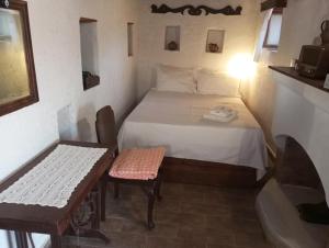a bedroom with a bed and a table and a chair at Lindia Athena Traditional House in Karpathos
