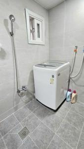 y baño con ducha y nevera pequeña. en Byulchae Guest House - Foreigner Only, en Seúl