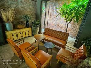 a living room with a couch and chairs and a table at Inchantreedoopool in Kanchanaburi City