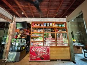 a coca cola store with a soda machine in front at Inchantreedoopool in Kanchanaburi City