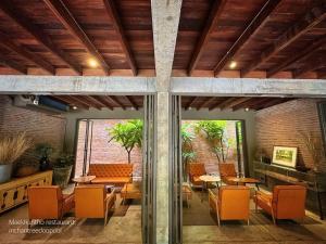 a dining room with orange chairs and tables at Inchantreedoopool in Kanchanaburi City