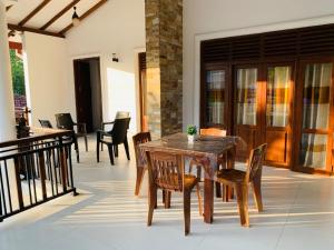 a wooden table and chairs on a patio at Kandula Holiday Resort in Anuradhapura