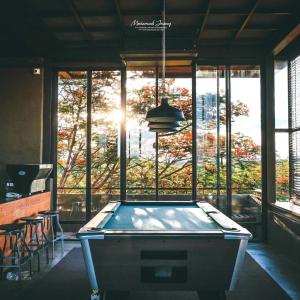 a pool table in front of a large window at Inchantreedoopool in Kanchanaburi City