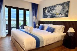 a bedroom with a large bed with blue and white pillows at Nuan Nil Secret Courtyard in Chiang Mai