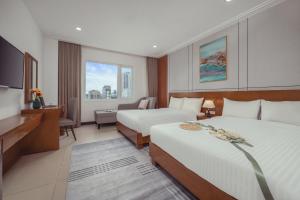 a hotel room with two beds and a television at Star Hotel and Spa Danang in Danang