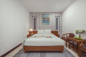 a bedroom with a bed and a table at Star Hotel and Spa Danang in Danang