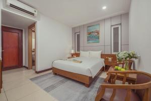 a bedroom with a bed and a chair in it at Star Hotel and Spa Danang in Danang
