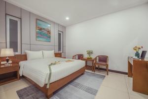 a bedroom with a bed and a desk and a chair at Star Hotel and Spa Danang in Danang